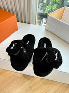 Black faux-fur slide slippers with V-logo detail on the strap