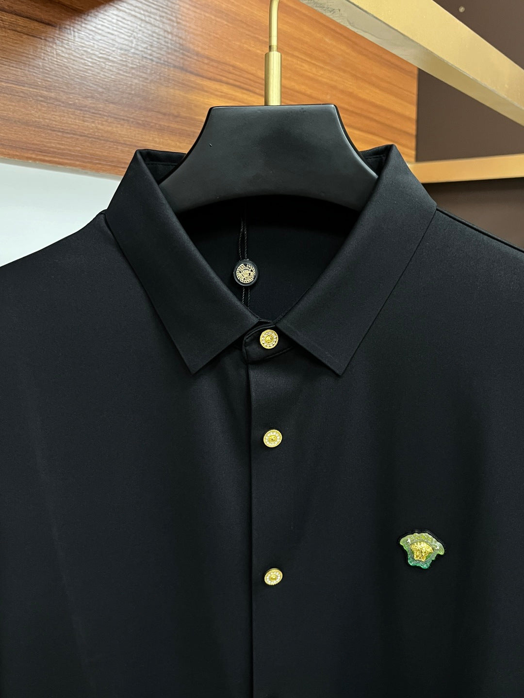 Versace black dress shirt close-up with pointed collar and gold buttons