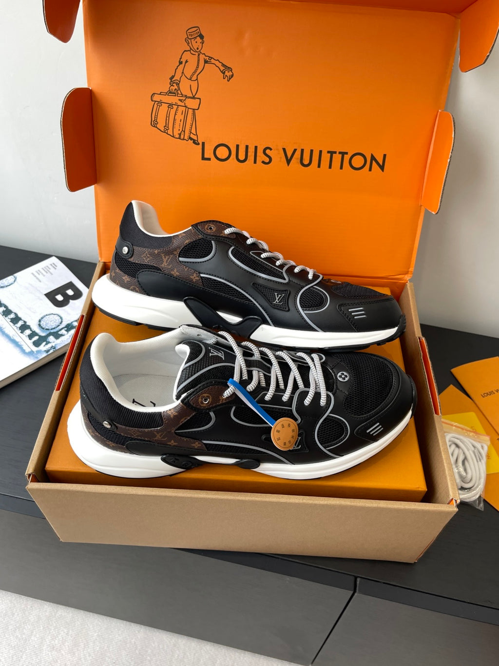 Louis Vuitton ladies sneakers angled view, black uppers with white soles and lace-up front