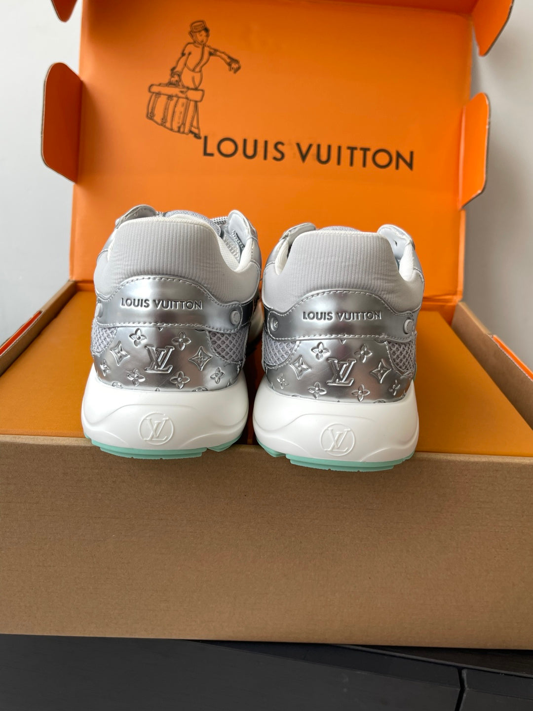 Back view of silver ladies sneakers with embossed heel logos and mint sole trim