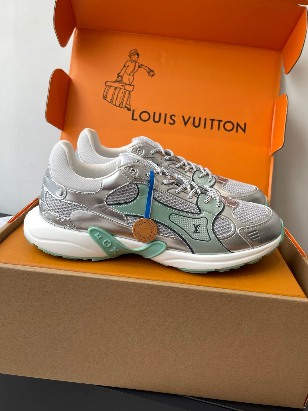 Side view of silver mesh ladies sneakers with mint panels and lace-up closure