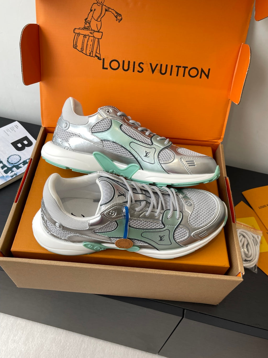 Pair of silver mesh ladies sneakers with mint panels and lace-up design in box