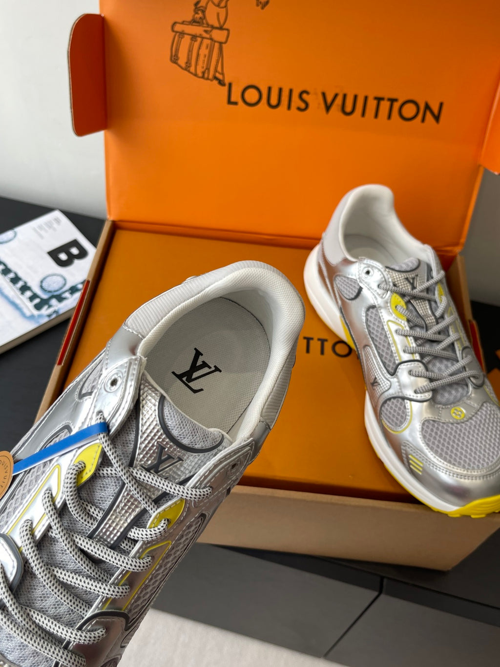 Silver Louis Vuitton sneakers for women, close-up heel view with LV emblem