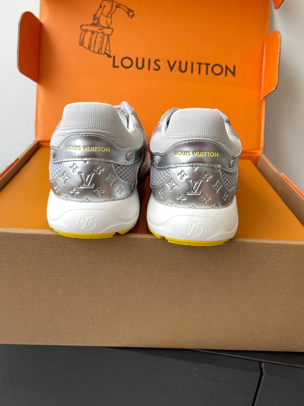 Silver Louis Vuitton sneakers for women, rear view with white heel tabs and LV print