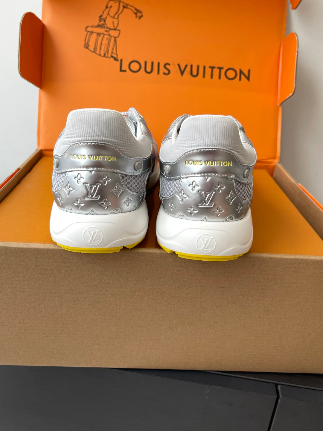 Silver Louis Vuitton sneakers for women, rear view with white heel tabs and LV print