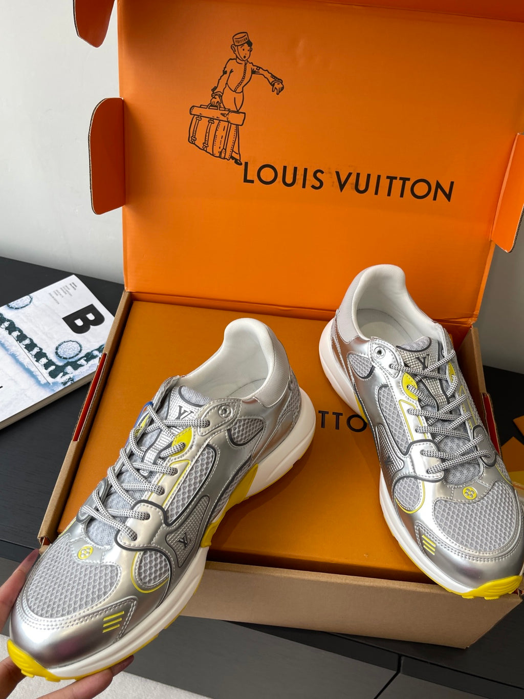 Silver Louis Vuitton sneakers for women, angled view with colorful laces and yellow soles