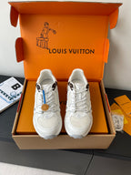 White lace-up sneakers in an open orange box, front view with two shoes displayed.