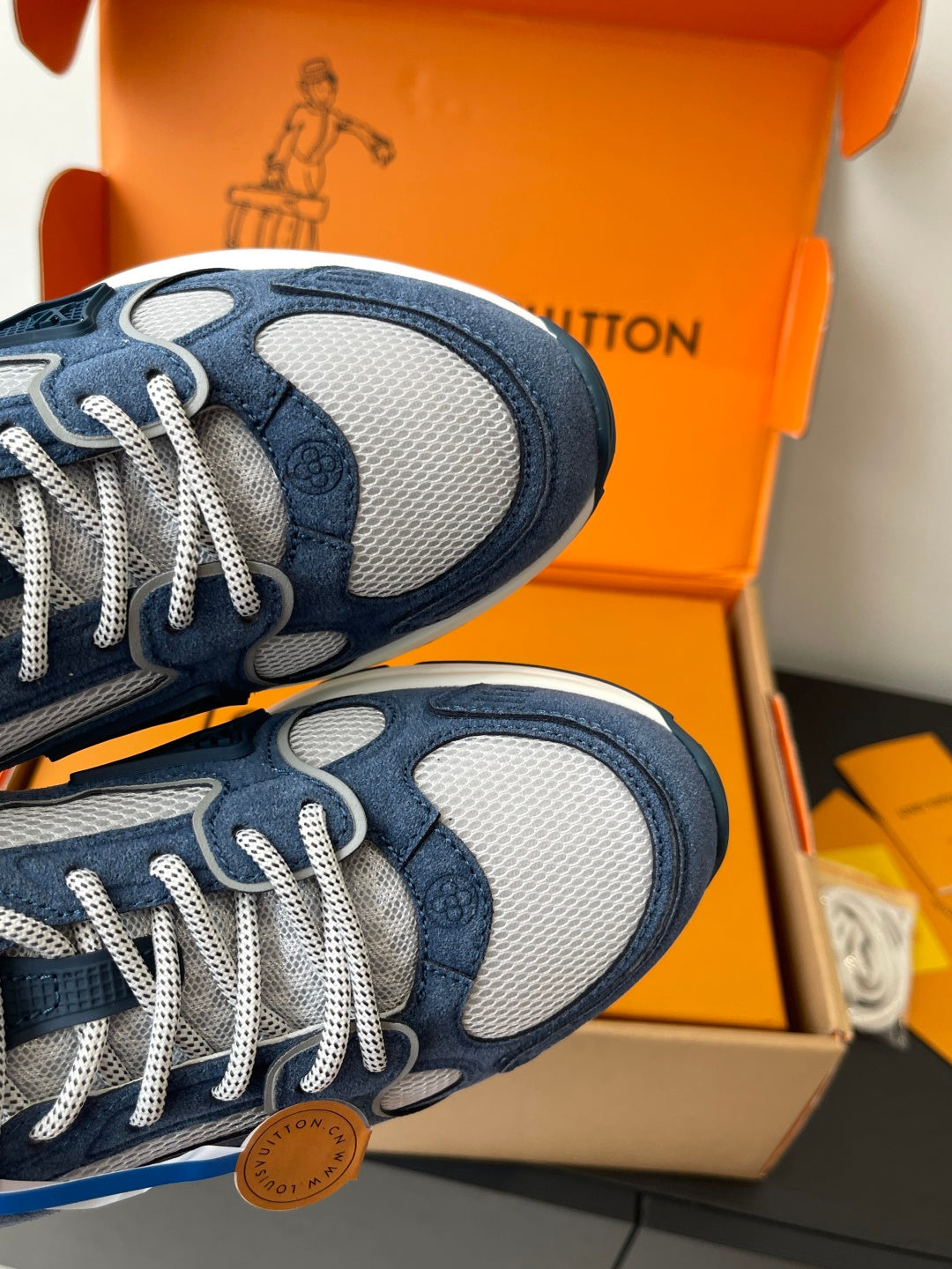 Close-up of navy and gray sneakers with white laces and textured side panels