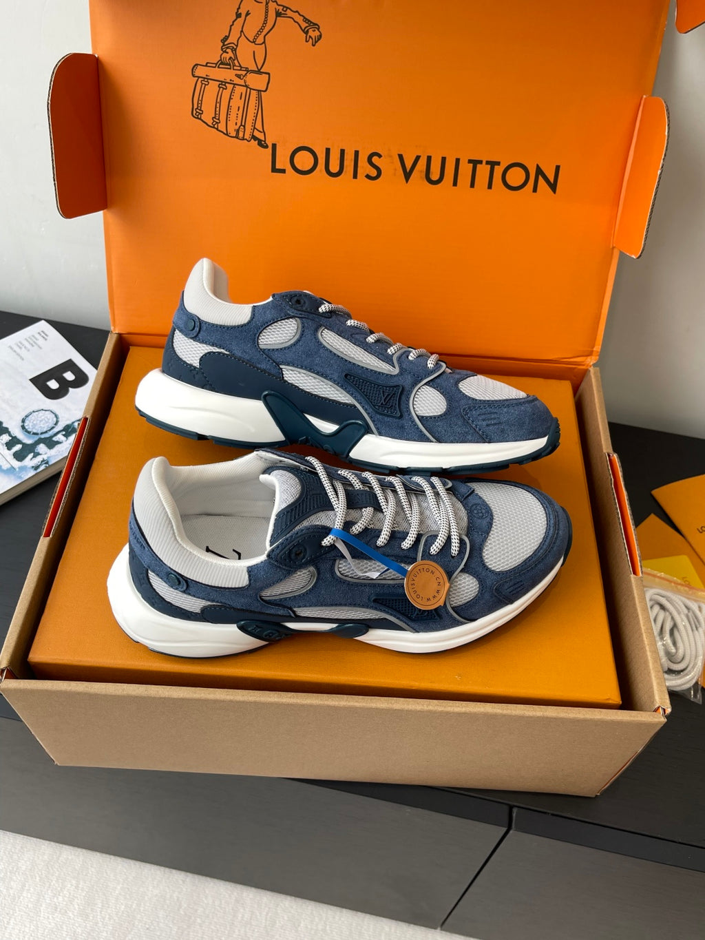 Navy and white lace-up sneakers with tan button detail and contrasting soles