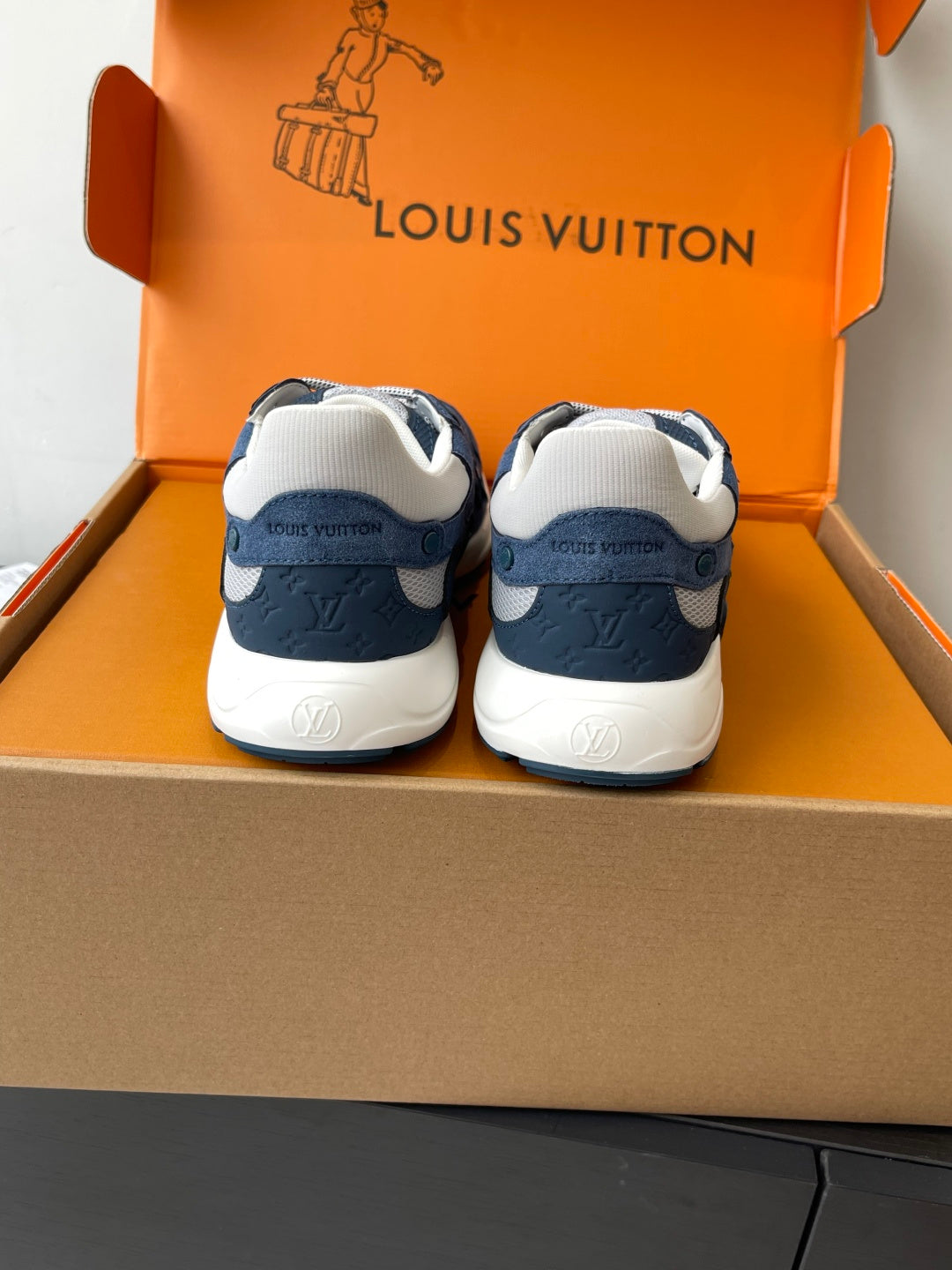 Back view of navy-and-white lace-up sneakers with cushioned heel and trim