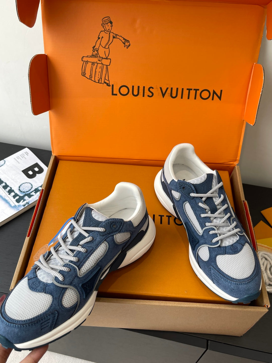 Two navy-and-white lace-up sneakers with white soles and cushioned uppers