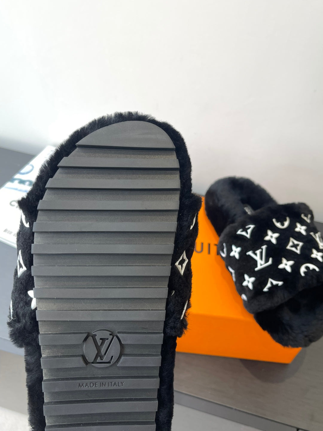 Black plush slide sandal with textured rubber sole, monogram strap