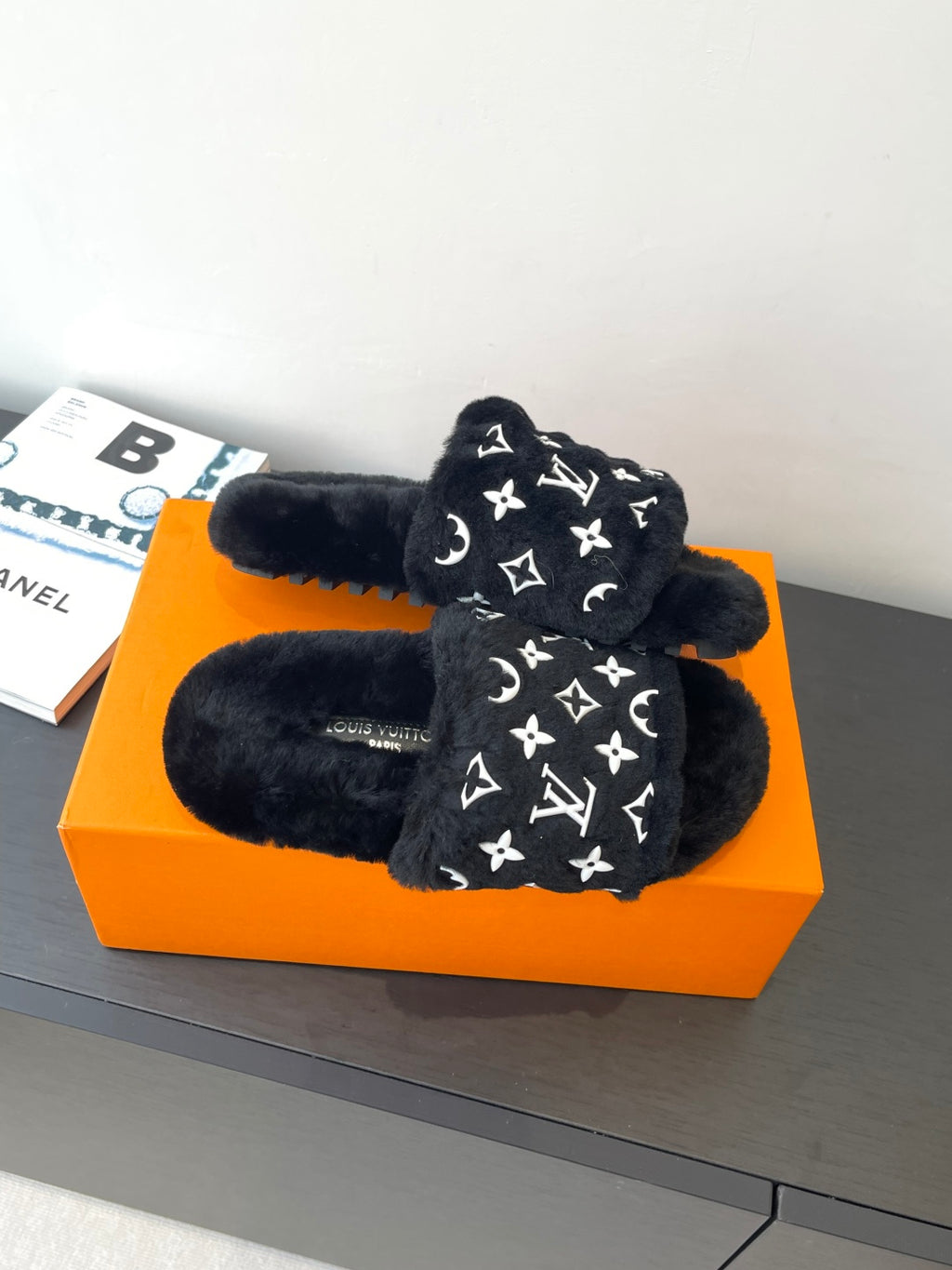 Black plush slide sandals with white monogram pattern, cushioned straps