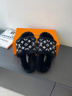 Black plush mule slide sandals with repeating white monogram pattern