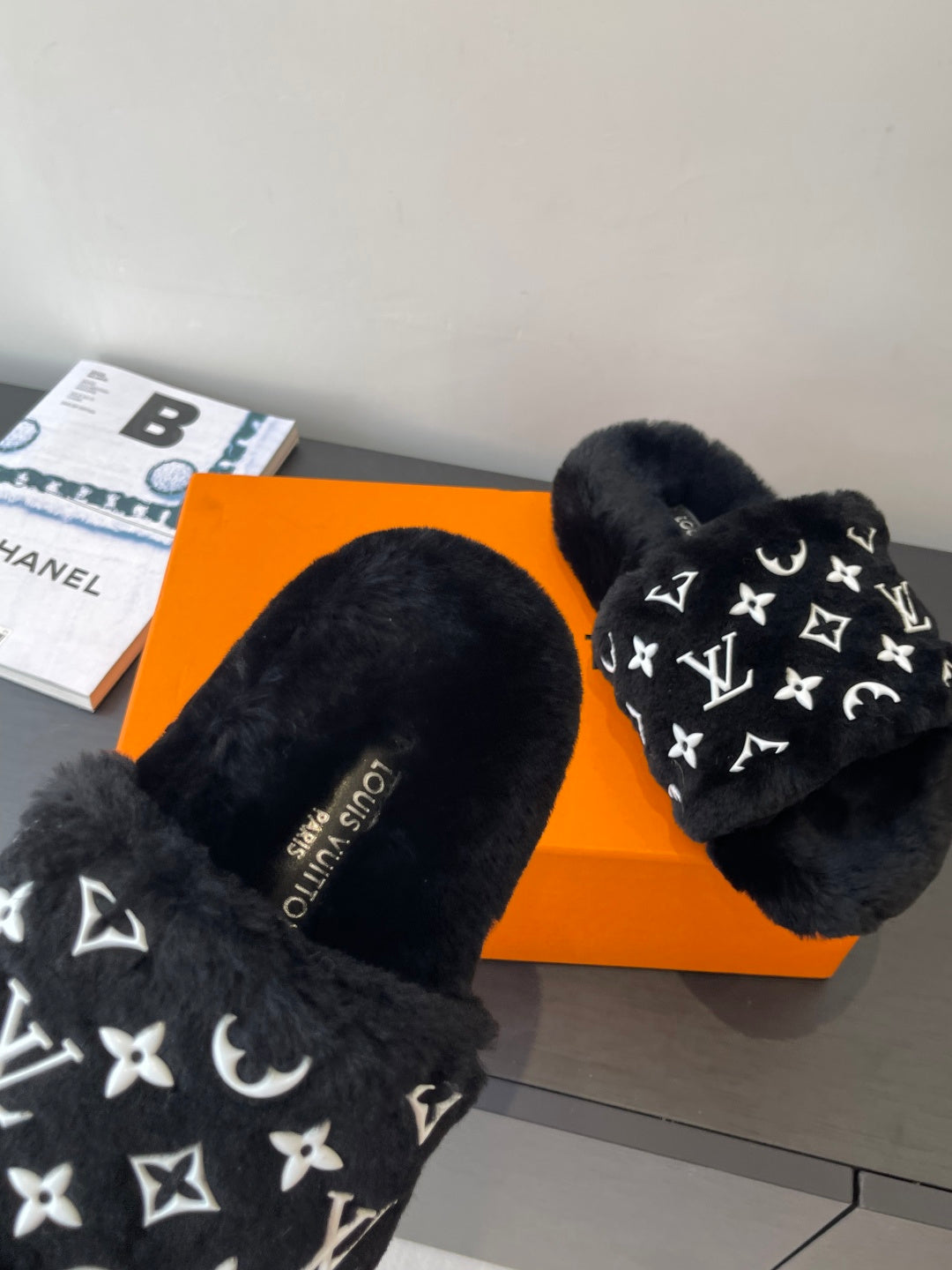 Black plush slide sandals with white monogram print, slip-on mule style