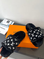Pair of black plush slide sandals with white monogram print and open toe