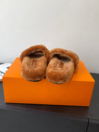 Brown plush slide sandals with curved heels and soft crossover straps.