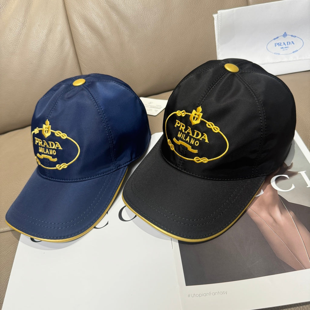 Two Prada caps: navy and black, each with yellow PRADA MILANO logo patch