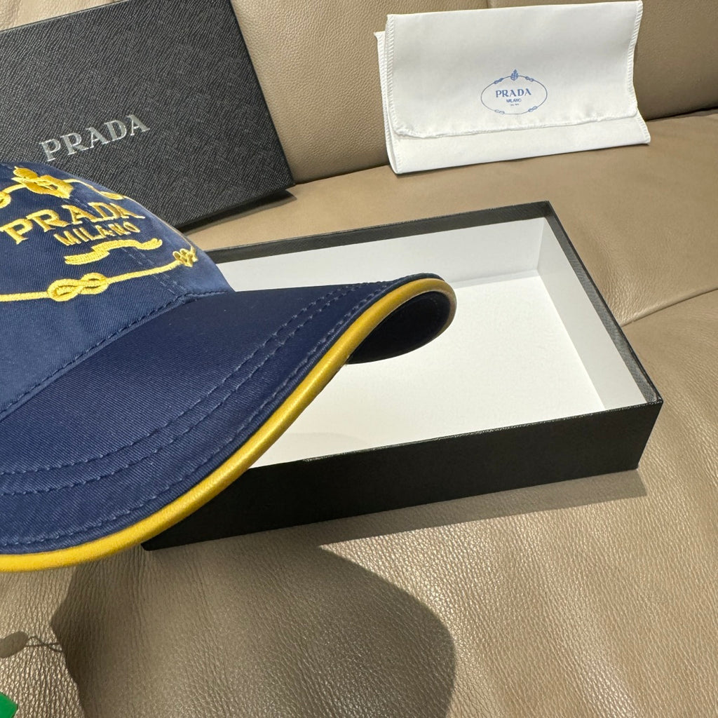 Prada cap brim detail in dark blue with yellow piping along the edge.