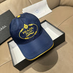 Prada cap in dark blue with gold logo patch and yellow-edged brim.