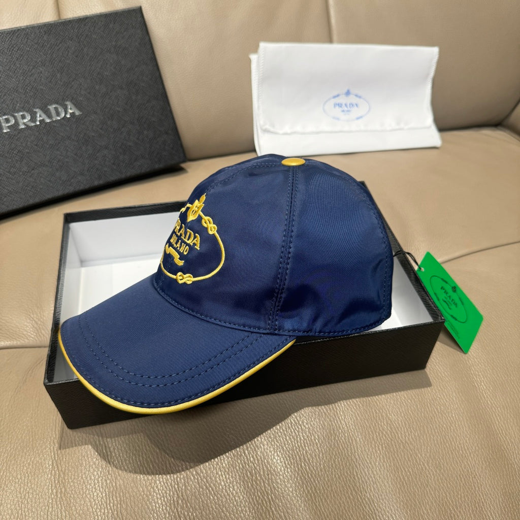 Prada cap, dark blue with embroidered PRADA MILANO badge and yellow-trim brim.