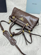 Prada brown leather top-handle bag with gold buckles and logo triangle front