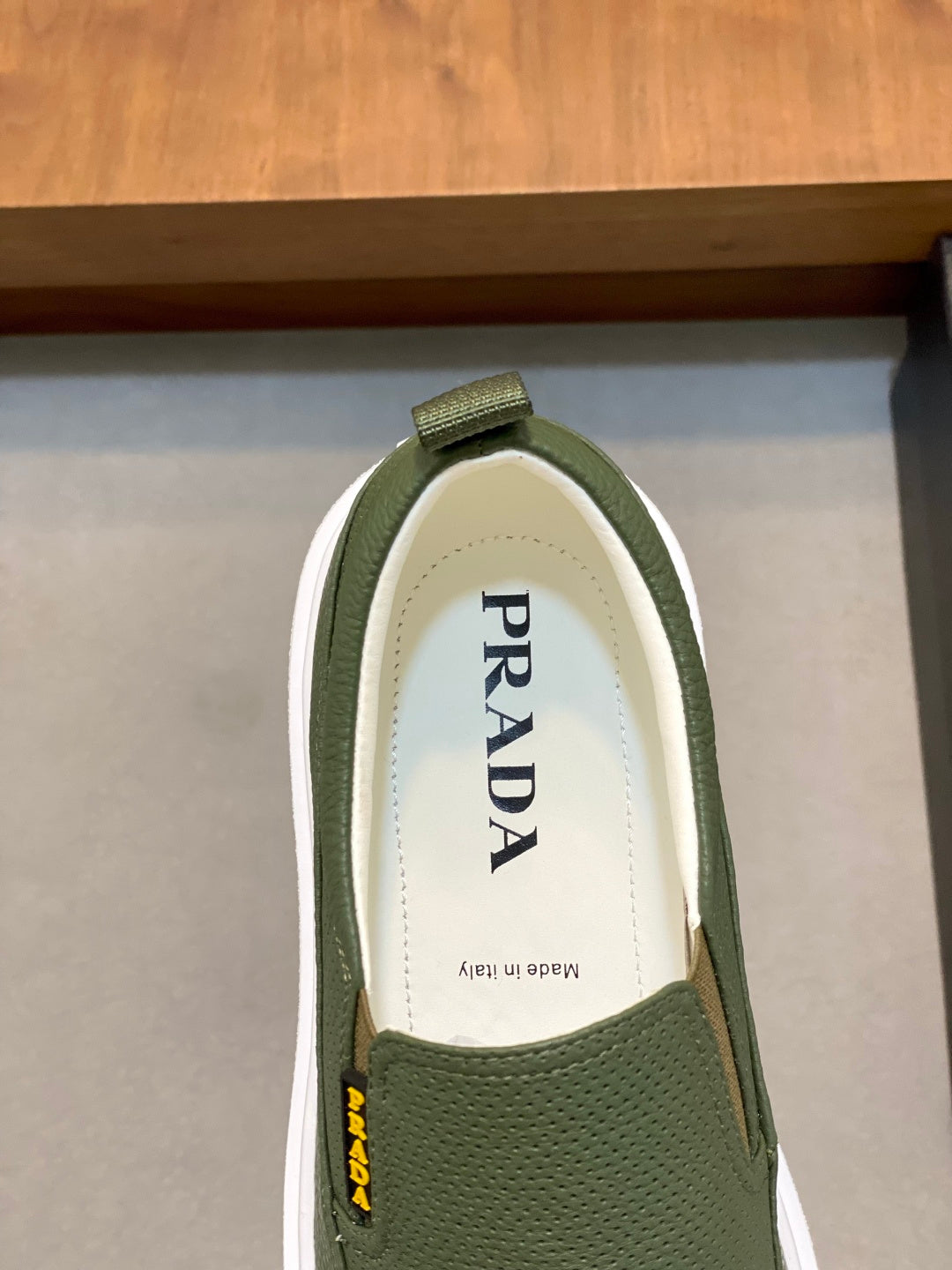 Prada unisex slip-on shoes, close-up of green insole with Prada lettering