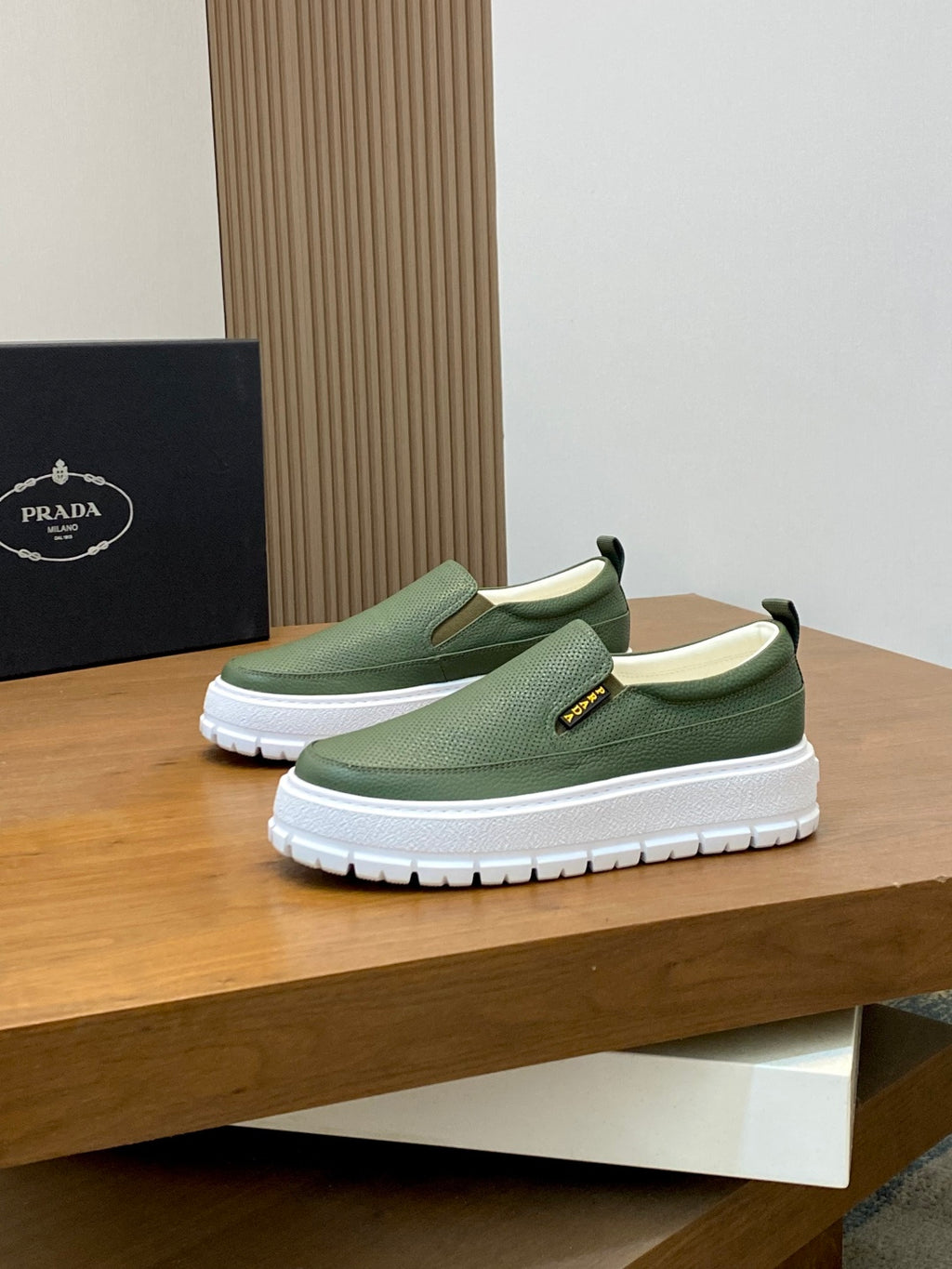 Prada unisex slip-on shoes on display, green upper with white platform sole