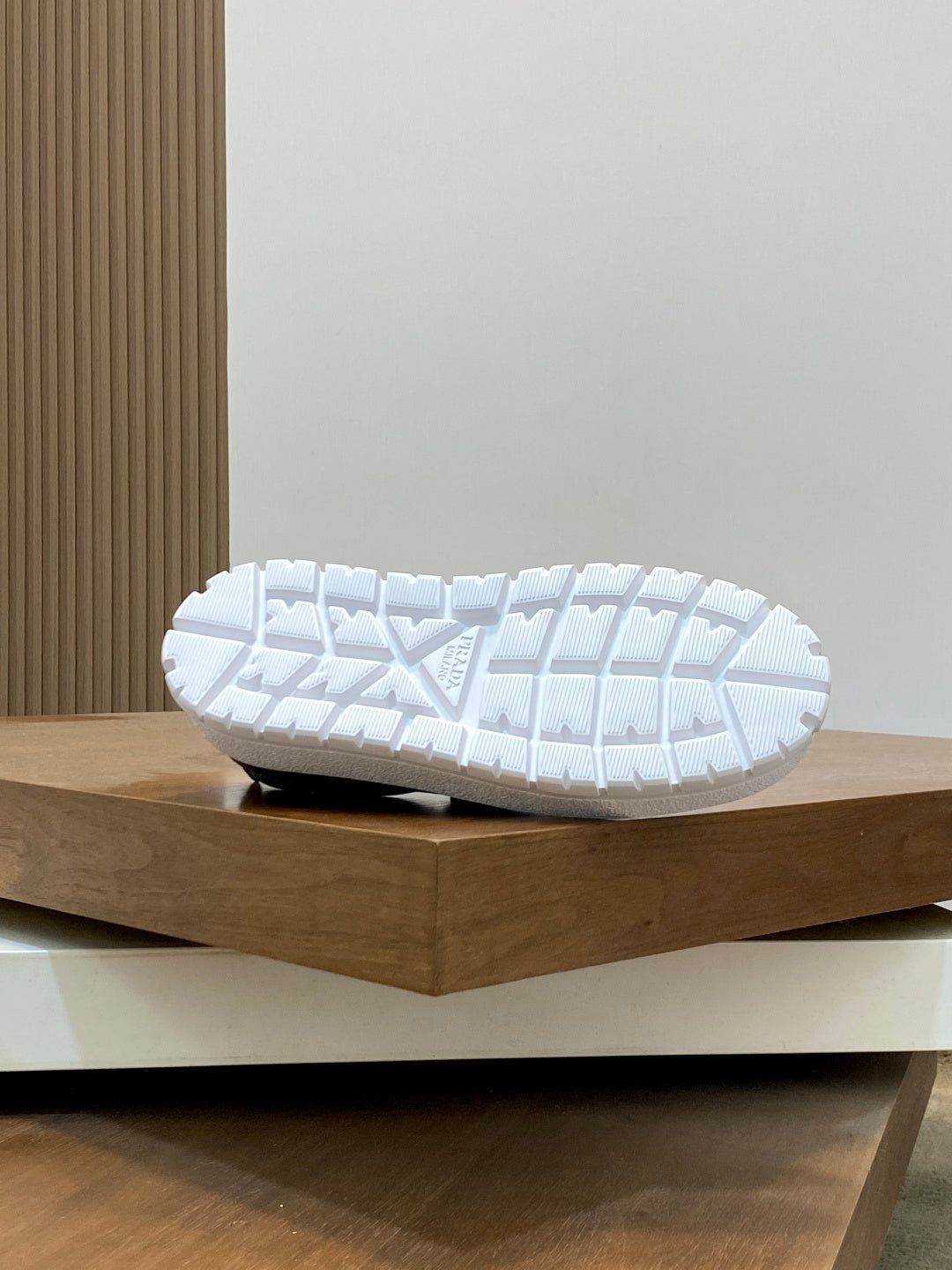 Prada unisex slip-on shoe outsole view, white tread sole on display