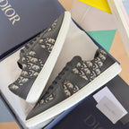 Low-top sneakers, dark gray leather and Dior monogram uppers, black laces, chunky white sole.