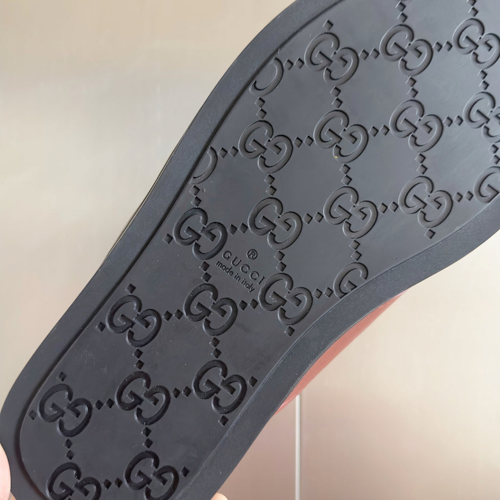 Gucci dark rubber sandal outsole with raised GG logo pattern.