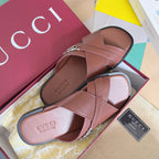 Gucci pink leather slide sandals with wide crossover straps and silver GG buckle.