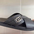Gucci black leather slide sandal with round silver G logo buckle on strap