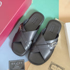 Gucci black slide sandals with crossed straps and silver G buckle, pair view