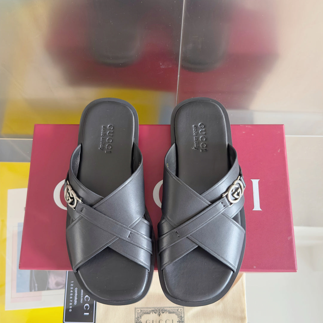 Gucci black slide sandals with crossover straps and silver G buckle, front view