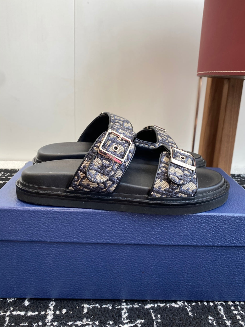 Dior slide sandals with black footbed, blue patterned straps and rectangular buckle