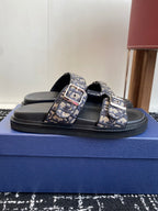 Dior slide sandals with black footbed, blue patterned straps and rectangular buckle