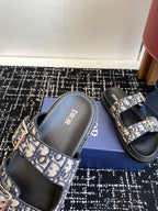 Dior sandals close-up with blue patterned strap over black footbed and insole branding