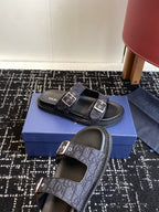 Dior sandals with dark blue patterned straps and silver buckles, shown on blue box