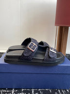 Dior slide sandals with two dark blue patterned straps and silver buckles on black sole