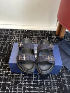 Dior slide sandals with dark blue patterned straps, silver buckles, and cushioned footbed