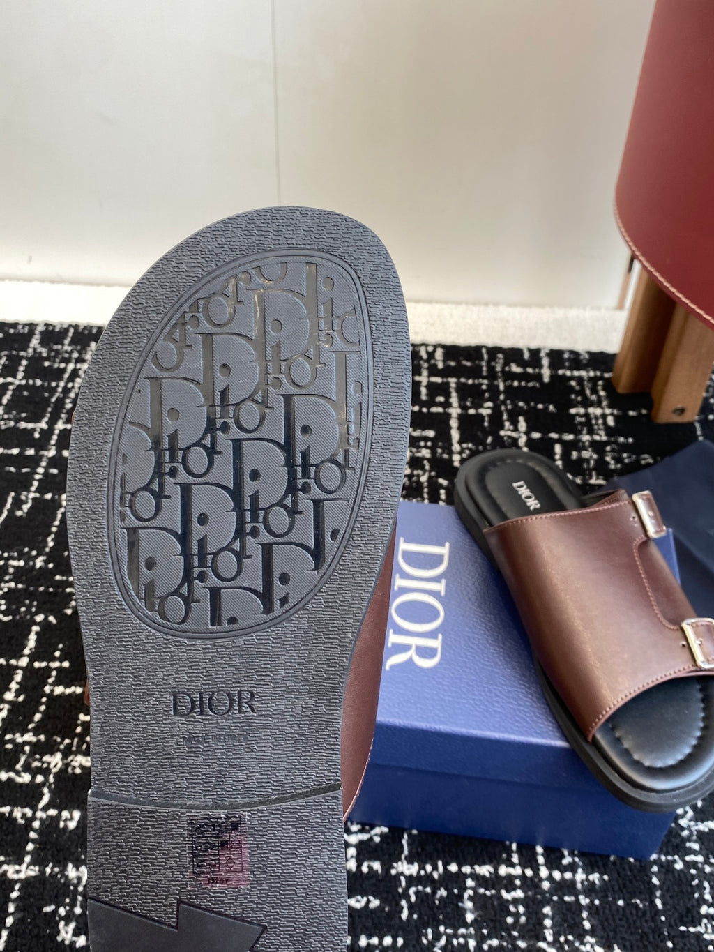 Dior sandal outsole close-up with textured tread and logo; taupe strap upper