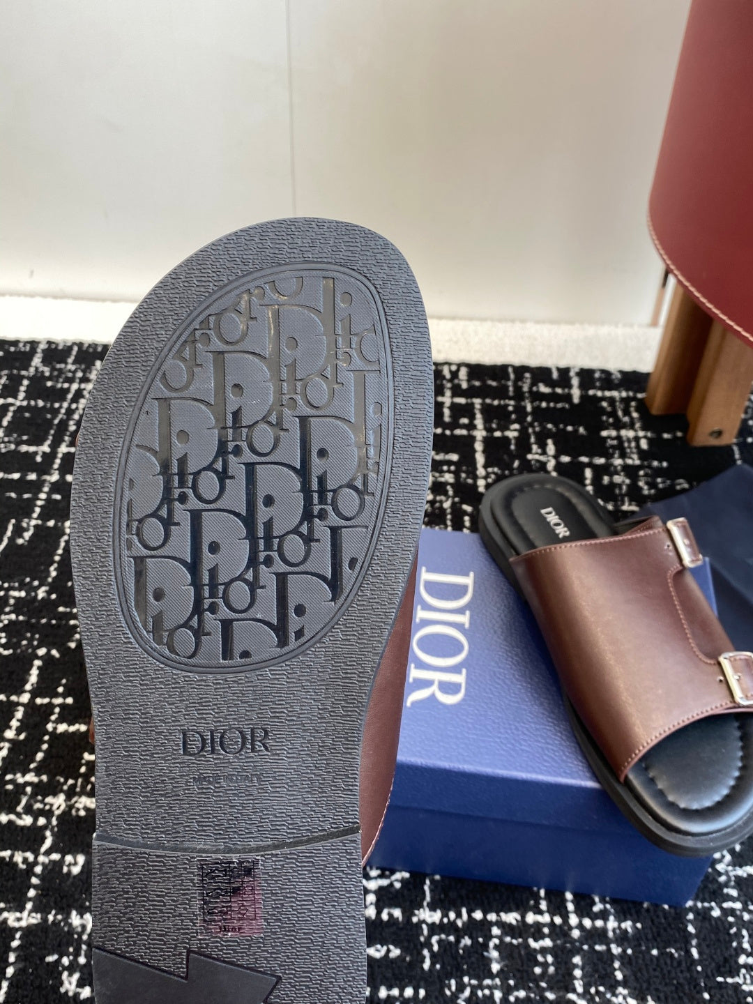 Dior sandal outsole close-up with textured tread and logo; taupe strap upper