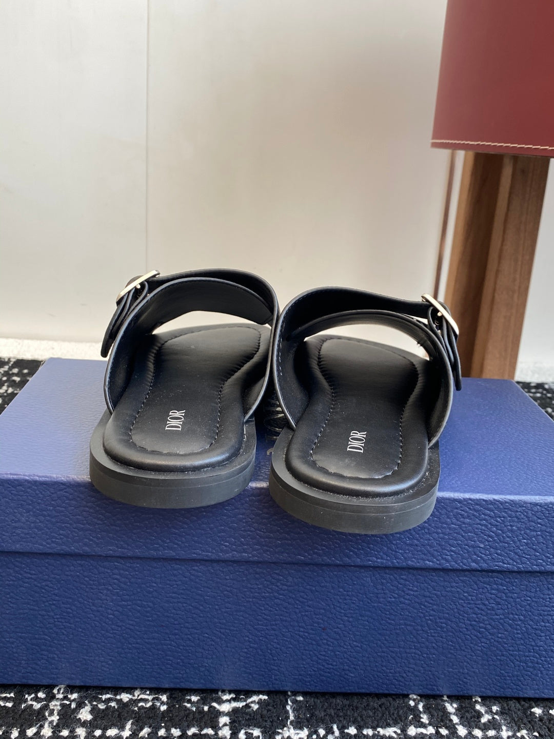 Back view of dark gray leather Dior slide sandals with strap buckles