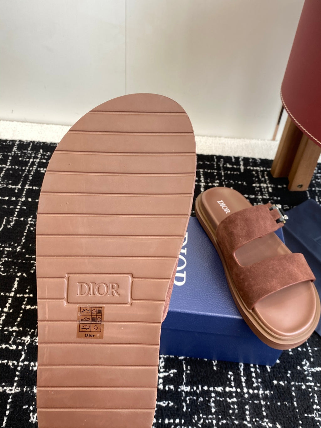 Dior sandals outsole close-up with embossed logo; brown suede slide sandal on box