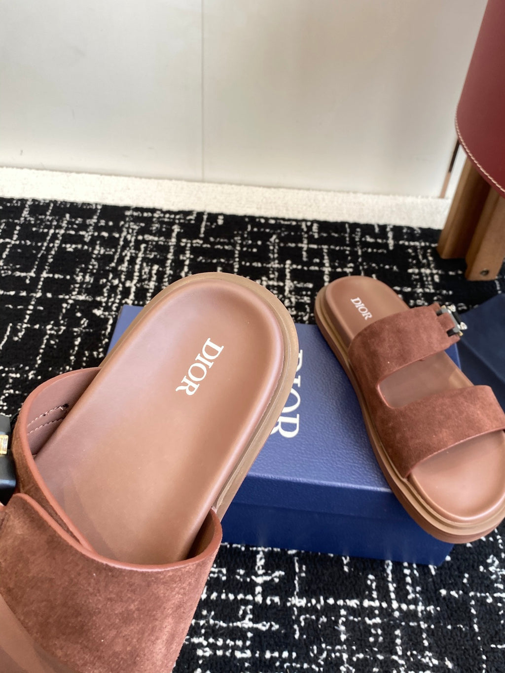 Dior slide sandals close-up on box, brown suede straps with silver buckle hardware