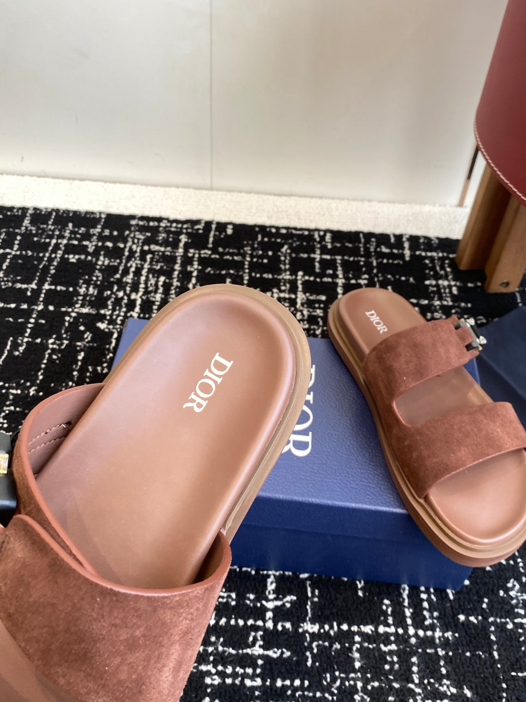 Dior slide sandals close-up on box, brown suede straps with silver buckle hardware