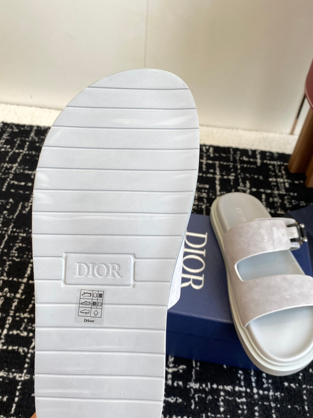Dior sandal outsole with tread, paired with light gray suede slide upper and silver buckle