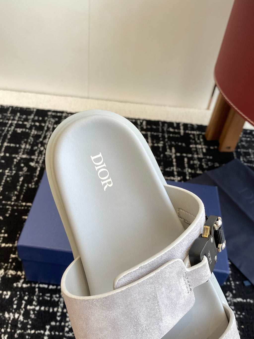 Dior slide sandal with light gray suede strap and silver buckle, white leather footbed