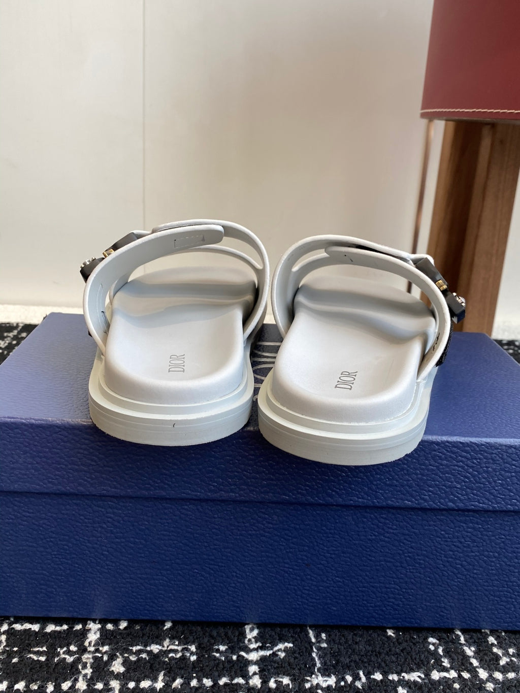 Dior sandals back view with light gray suede straps, silver buckles, white soles